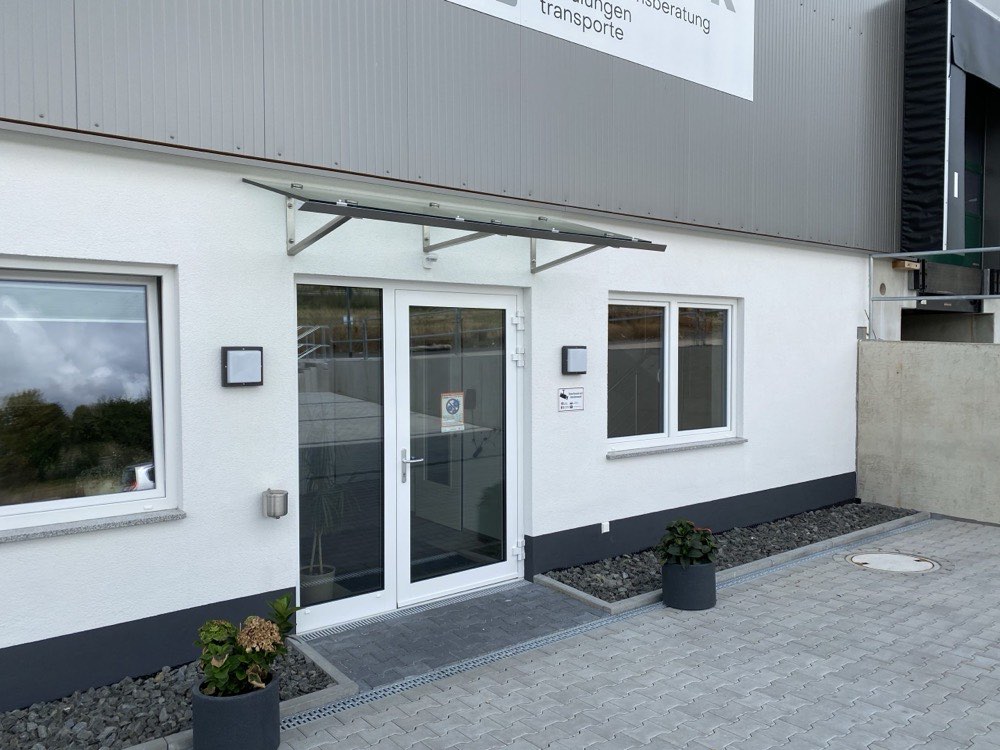 Eingangsbereich eines Firmengebäudes mit Glasvordach